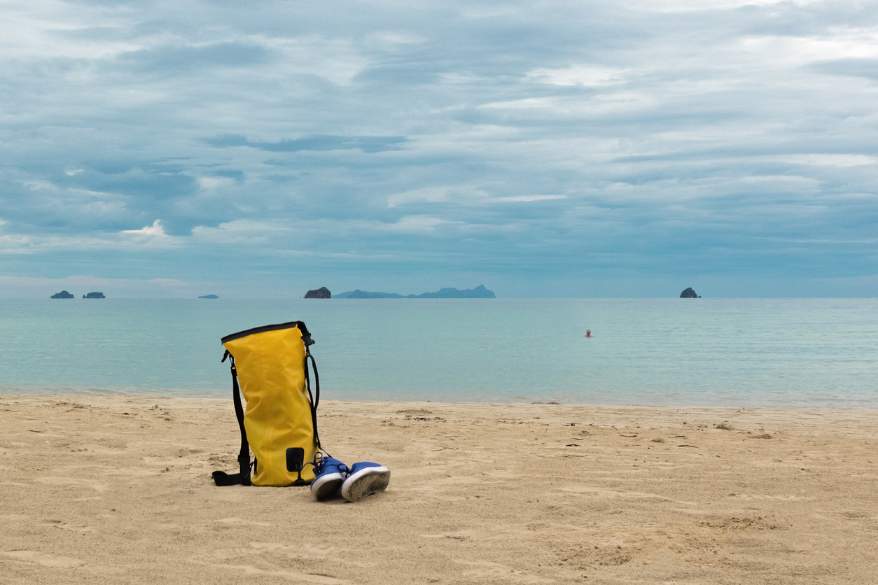 Mochila impermeable Mochila impermeable amarilla en la playa